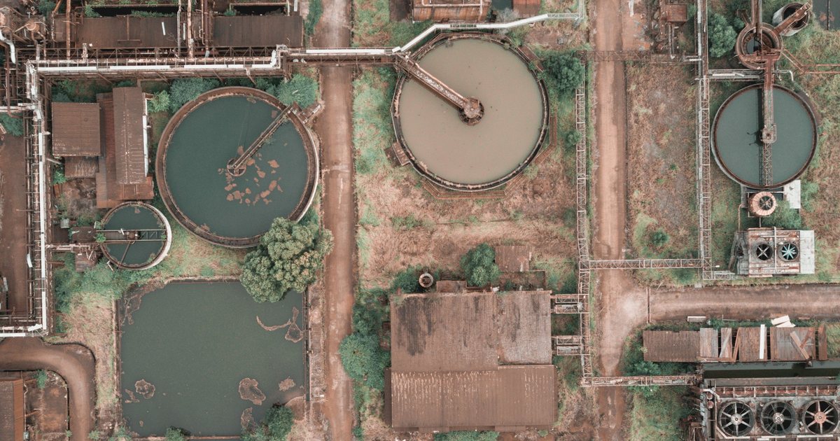 Vista aérea de una planta industrial con balsas circulares de tratamiento de aguas