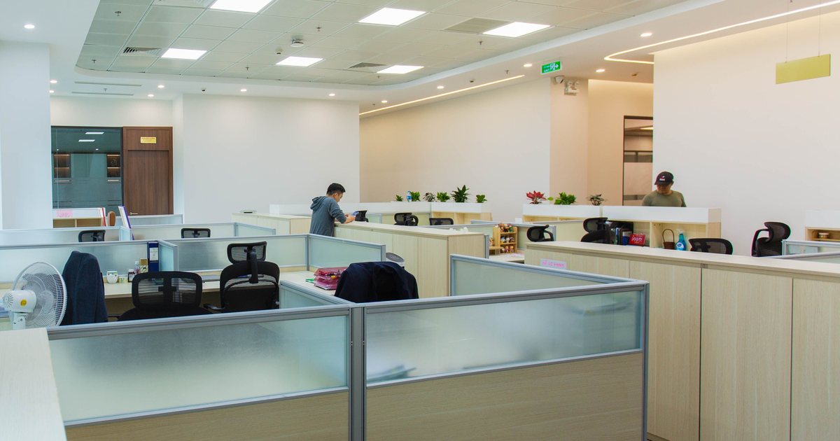 Oficina diáfana con cubículos de trabajo y empleados en su puesto