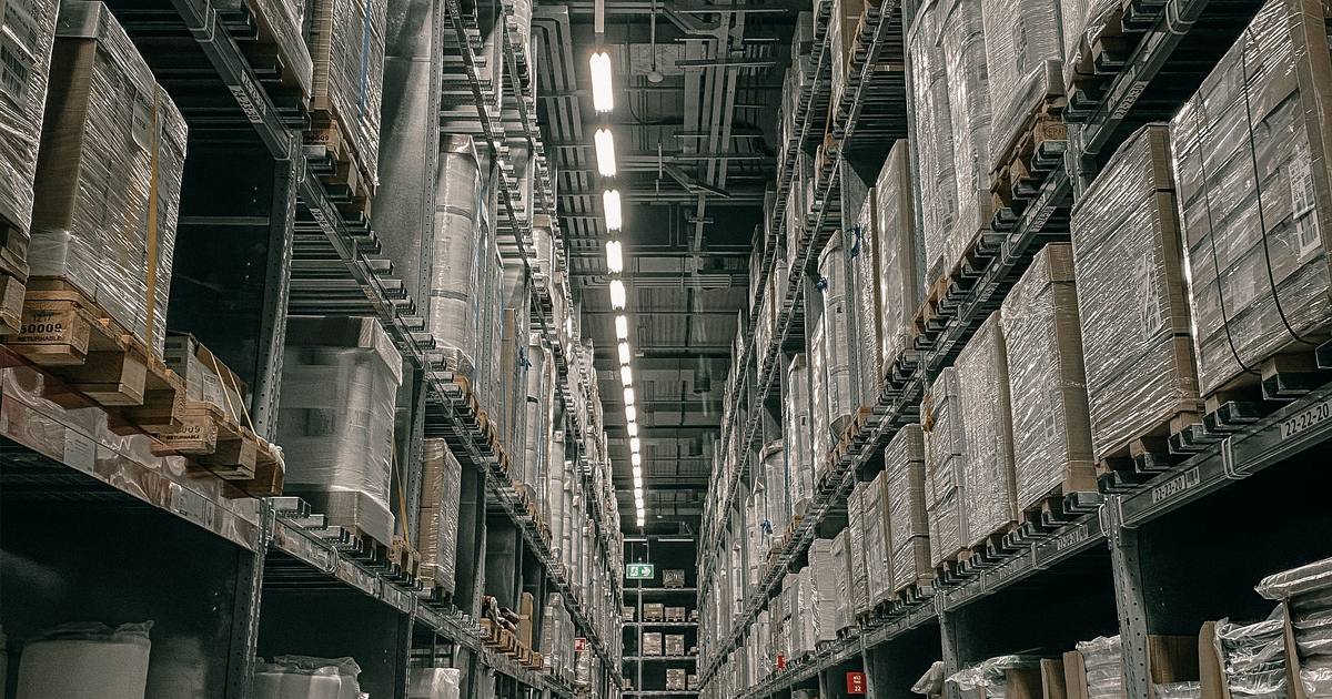 Pasillo central de un almacén de gran altura con estanterías llenas