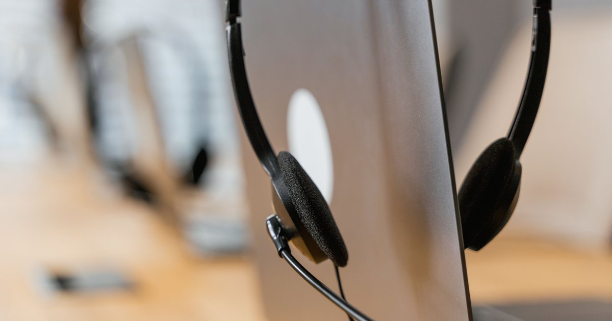 Auriculares de atención al cliente apoyados sobre la tapa de un portátil