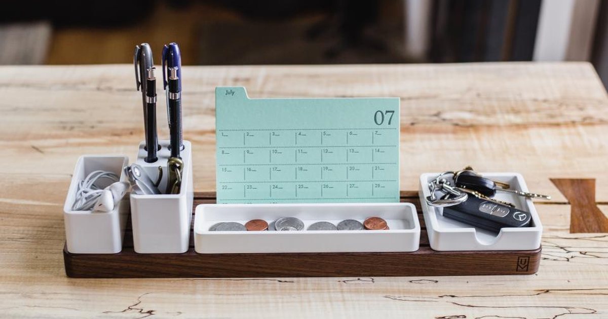 Organizador de escritorio de madera con una tarjeta de calendario y bolígrafos