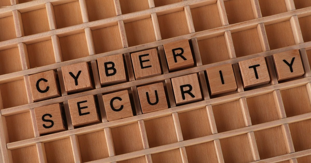 Letras de madera formando las palabras «cyber security» sobre una superficie de madera