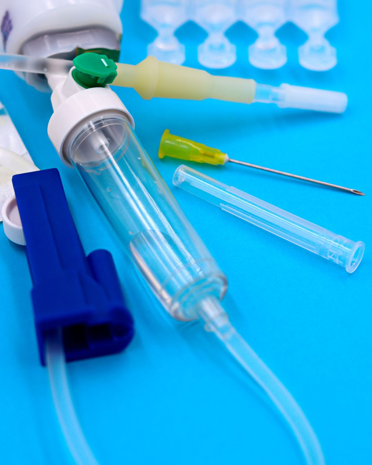 Jeringuillas, agujas y tubos de uso médico sobre un fondo azul