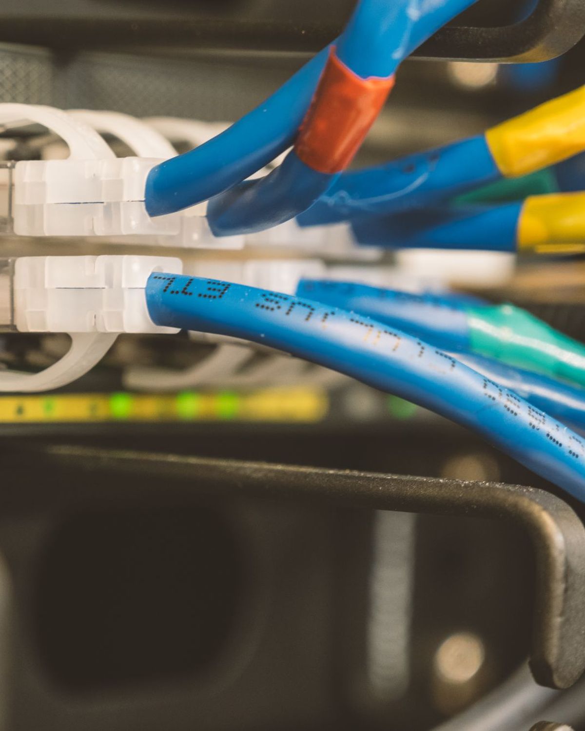 Cables de red azules conectados a un conmutador con etiquetas de colores