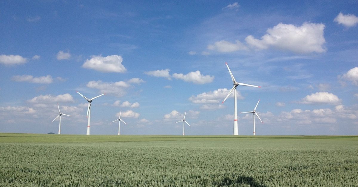 Aerogeneradores de energía eólica en un campo verde bajo un cielo despejado